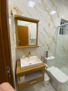 a bathroom with a sink and a toilet at Casa da Tieko in Ilhabela +17 photos