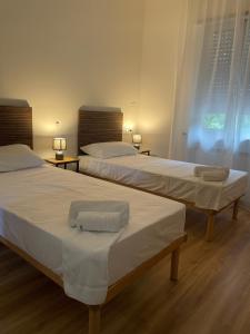 two beds in a hotel room with towels on them at Affittacamere LICEN in Trieste +25 photos