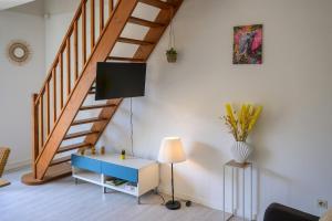 a living room with a staircase and a table and a lamp at Le jungle, hyper centre, balcon et terrasse in Tarbes