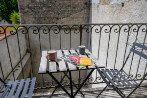a table with two cups and a book on a balcony at Le jungle, hyper centre, balcon et terrasse in Tarbes