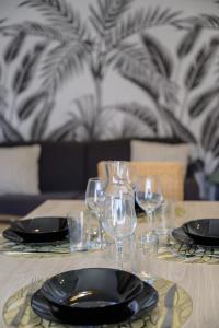 a table with plates and wine glasses on it at Le jungle, hyper centre, balcon et terrasse in Tarbes