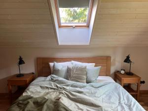 a bedroom with a large bed with a skylight at Bernātu Kalnmaļi in Bernāti
