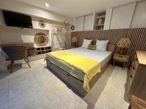 a bedroom with a large bed with a yellow blanket at Villa Naïma Esterel in Saint-Raphaël +91 photos