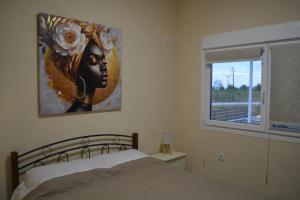 a bedroom with a bed and a painting on the wall at Sea Breeze House in Paralia Katerinis