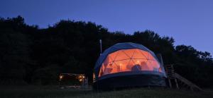a dome tent sitting in a field at night at GLAMPING Považie in Trenčín