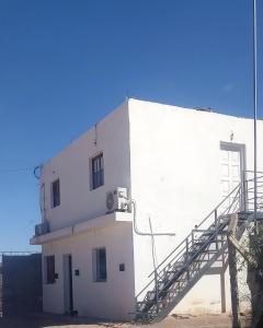 a white building with a staircase on the side of it at Departamento turístico Cloe 2 in Fiambala