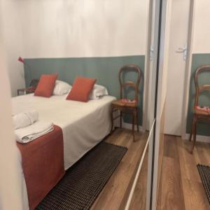 a bedroom with a bed with red pillows and two chairs at Galerie d'art Nakai - Hyper Center - By Primo in Tournus +38 photos