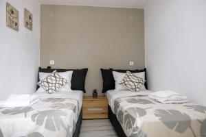 two beds sitting next to each other in a room at Modern House Close to the Sea Asprovalta in Asprovalta