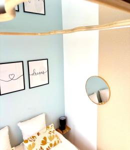 a bedroom with a bed with a mirror and framed pictures at Studio chaleureux climatisé pre de Paris-Orly in Villeneuve-le-Roi