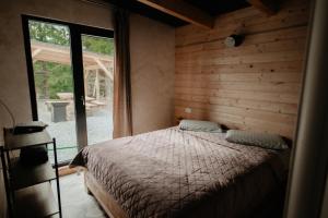 a bedroom with a bed and a large window at Măgura Ținutul Lupilor in Colibiţa
