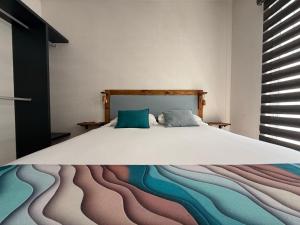 a bedroom with a bed with a painting on it at Puerta al Sol in Acapulco +31 photos