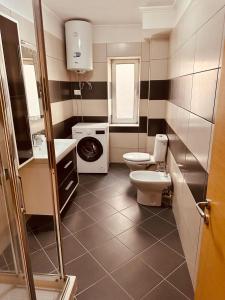 a bathroom with a toilet and a washing machine at Holiday Home Lezha 2 in Lezhë