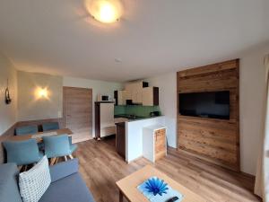 a living room with a couch and a table at Alpenzeit Zillertal Apartments in Zell am Ziller