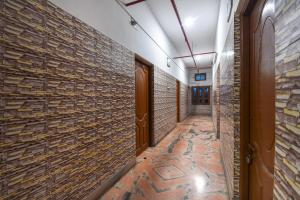 a hallway with brick walls and a tile floor at Hotel O Gour in Bāgnān