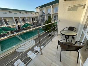 a balcony with a pool and a table and chairs at OSTRIV Hotel in Zatoka