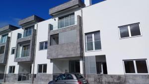 a car parked in front of a white building at Azure Escape Azores in Arrifes