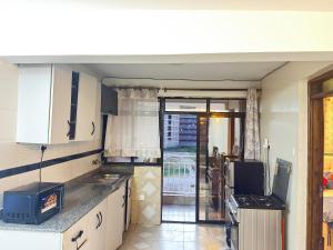 een keuken met een spoelbak en een fornuis bij Executive homes in Kitengela 