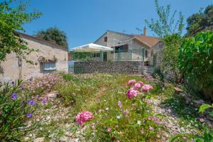 a garden with pink flowers in front of a house at Rena's house in Zenempisátika