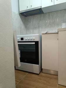 a kitchen with a stove and white cabinets at LA CASA Di GIORGIO in Pentati +15 photos