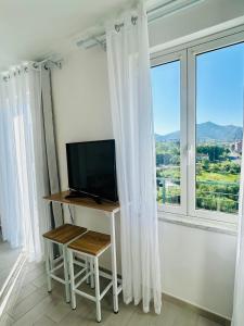 a television sitting on a table in front of a window at Casa Sbollazza con parcheggio e vicino al parco in Sestri Levante