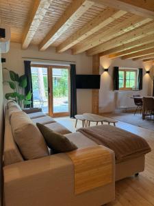 una sala de estar con un sofá grande y techos de madera. en Huize Eléna, en Lochem