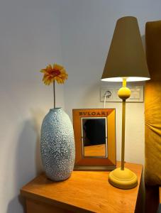 a vase on a table with a lamp and a picture at Apartment Natasa in Rab