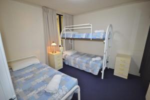 a bedroom with two bunk beds and a window at Riverview Holiday Apartment 93 - Kalbarri WA in Kalbarri