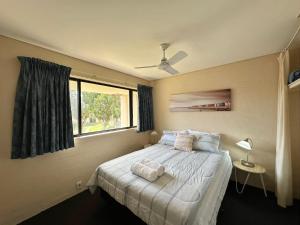 カルバリにあるRiverview Holiday Apartment 68 - Kalbarri WAの窓のある白いベッドのある寝室