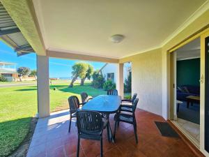 a patio with a table and chairs on a porch at Pelican Shore Villa 22 - Kalbarri WA in Kalbarri