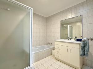 a bathroom with a tub and a sink and a shower at Pelican Shore Villa 20 - Kalbarri WA in Kalbarri