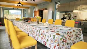 a long table in a kitchen with yellow chairs at Black Stone Family Garden Villa in Yaoqiaoyu