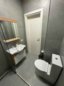 a bathroom with a toilet and a sink at Seaview Apartment in Dhërmi