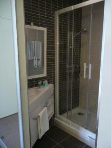 a bathroom with a shower and a sink and a mirror at Hotel Le Saint Aubin in Chevillé +18 photos
