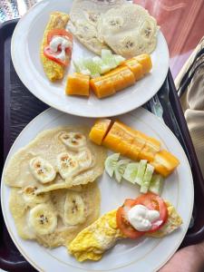 two plates of food on a tray with breakfast foods at Renata Cottages in Ohoililir +66 photos