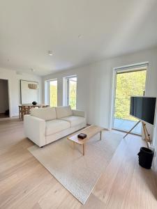 sala de estar blanca con sofá blanco y TV en Casa Cimili City, en Kristiansand