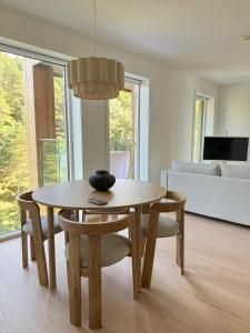 Una mesa de comedor y sillas en una sala de estar. en Casa Cimili City, en Kristiansand