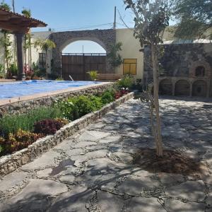 a tree in a courtyard next to a swimming pool at Casa de Campo luciérnaga in San Miguel de Allende
