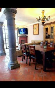 a dining room with a table and chairs and a chandelier at Casa de Campo luciérnaga in San Miguel de Allende