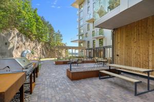 a patio with benches and tables and a building at Casa Cimili City in Kristiansand