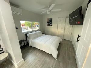 a bedroom with a white bed and a window at The Vice City Suite - Private stay with Free Parking in the Heart of Miami in Miami