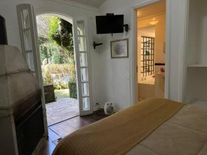 a bedroom with a bed and an open door at Pousada Di Oliva in Campos do Jordão