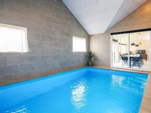 une grande piscine bleue dans une maison dans l'établissement 5 star holiday home in Idestrup, à Bøtø By