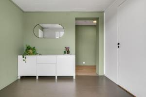 Un baño con un tocador blanco y un espejo. en Nice apartment on Futrikelva, en Tromsø