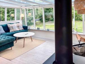 ein Wohnzimmer mit einem blauen Sofa und einem Tisch in der Unterkunft 6 person holiday home in Knebel-By Traum in Knebel