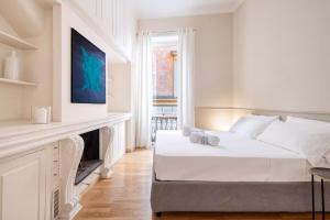 a white bedroom with a bed and a fireplace at Navona Boutique House in Rome