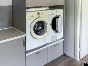 a washer and dryer in a small kitchen at Spacious Lakeside Retreat in Ansager