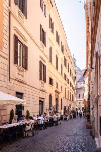a group of people sitting at tables in an alley at Navona Boutique House in Rome