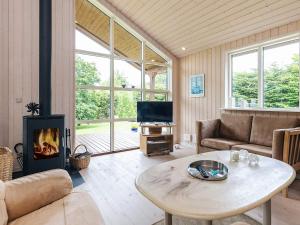 een woonkamer met een tafel en een open haard bij 6 person holiday home in Løgstør in Løgsted