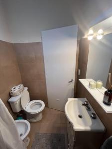 a small bathroom with a toilet and a sink at Departamento Naon SP in San Pedro
