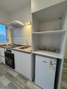 een keuken met witte kasten, een spoelbak en een vaatwasser bij Temporal Colonia Caroya in Colonia Caroya